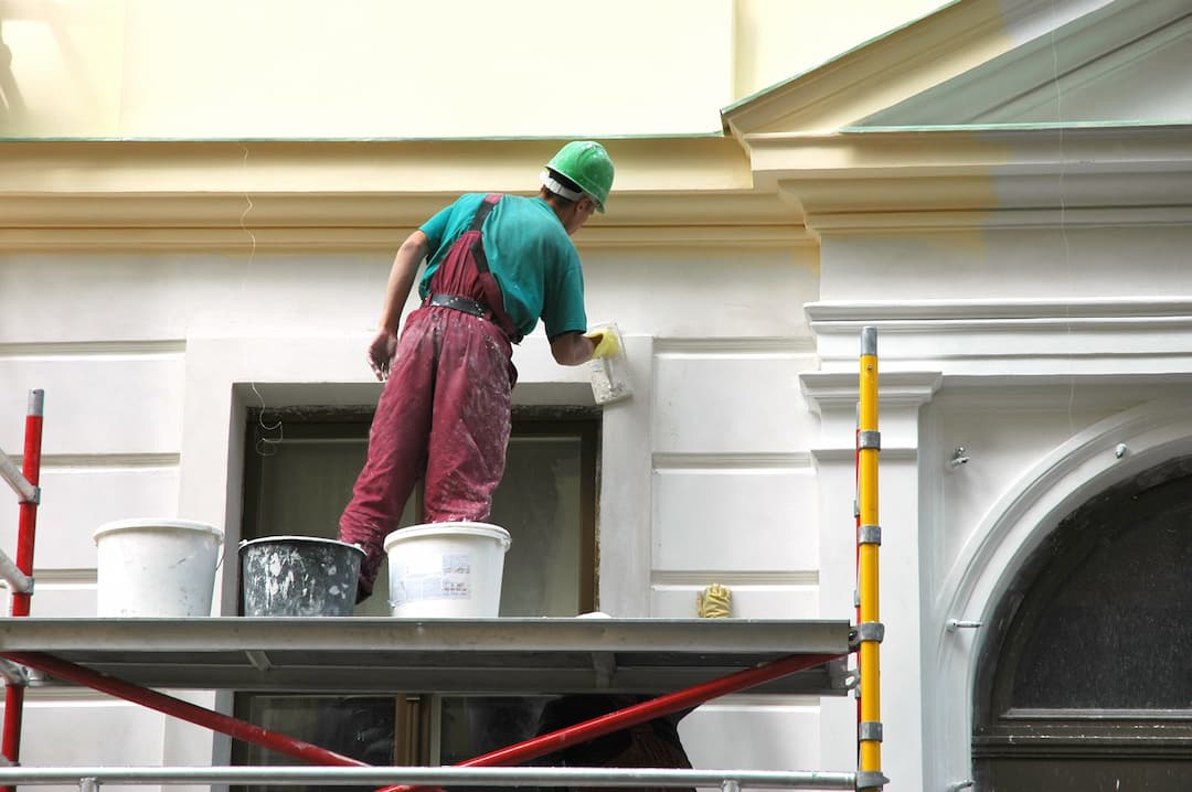 Exterior Painting Being Done By A Man On Scaffolding On A Period Property